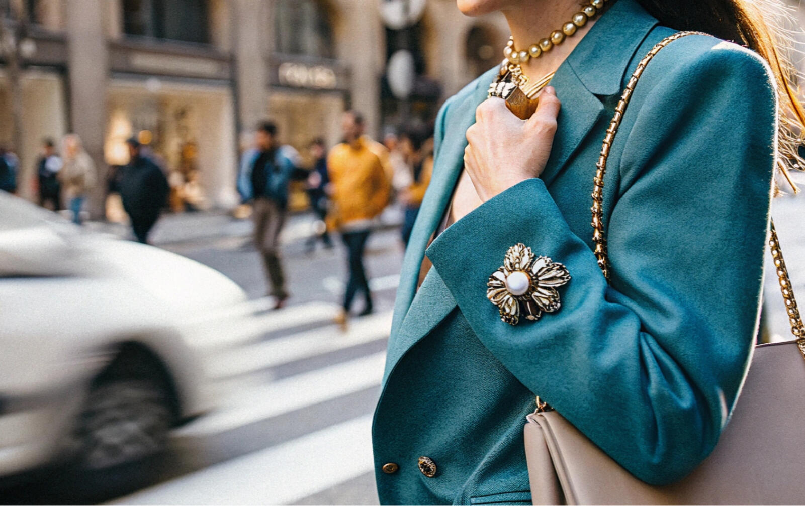 A brooch on the sleeve of a stylish woman's jacket in the city.