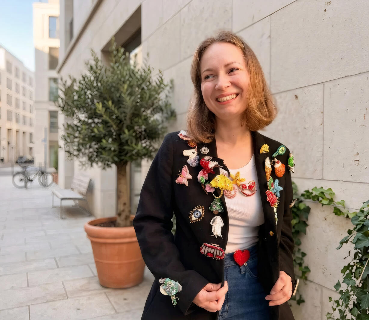 Olya wearing a black blazer covered with her beaded brooches
